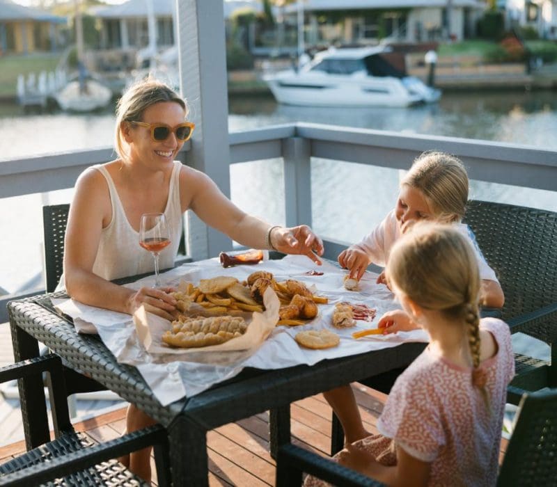 Guests dining on deck at Captains Cove Waterfront Apartments